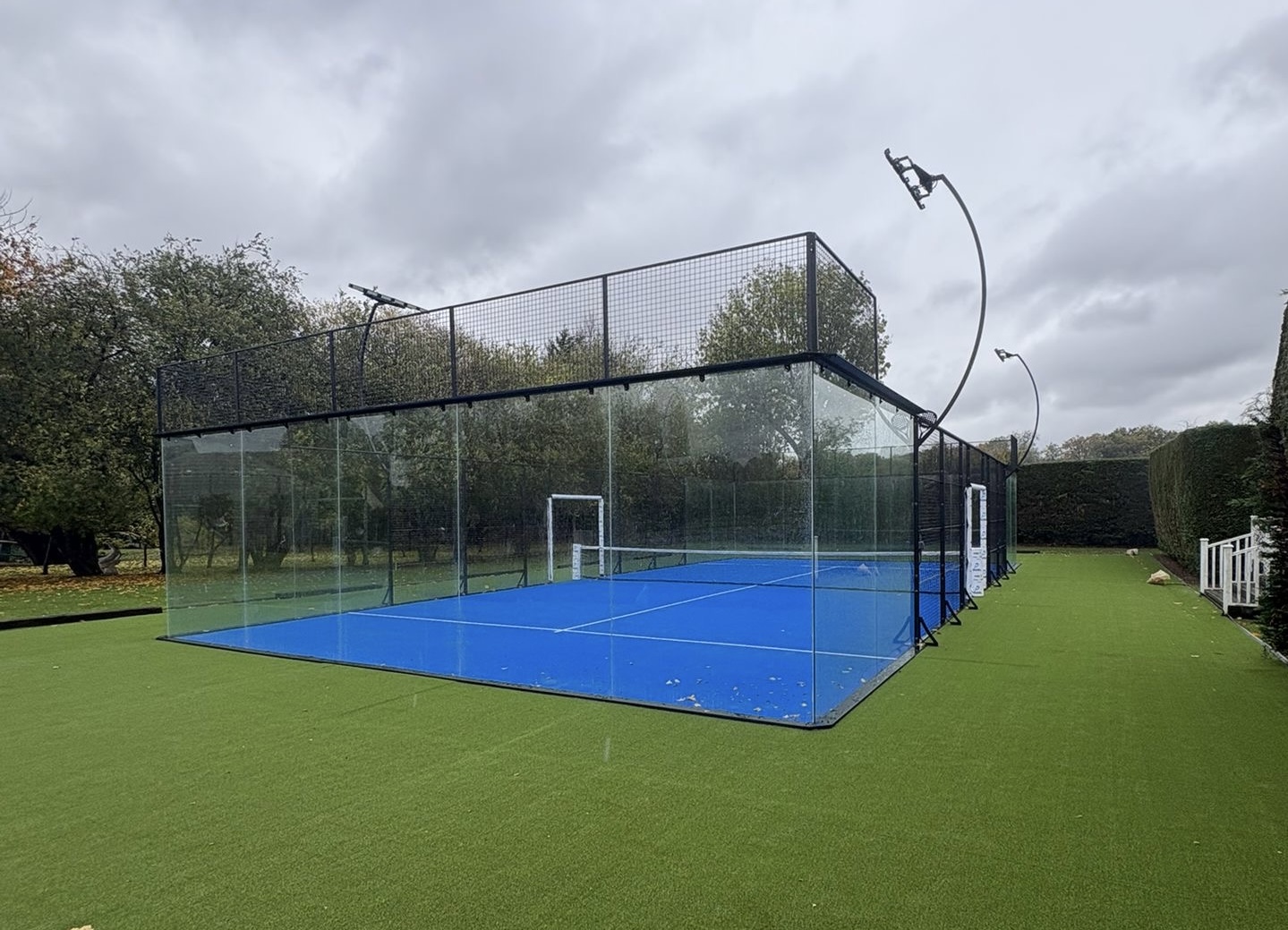 Glass padel court waiting for league night