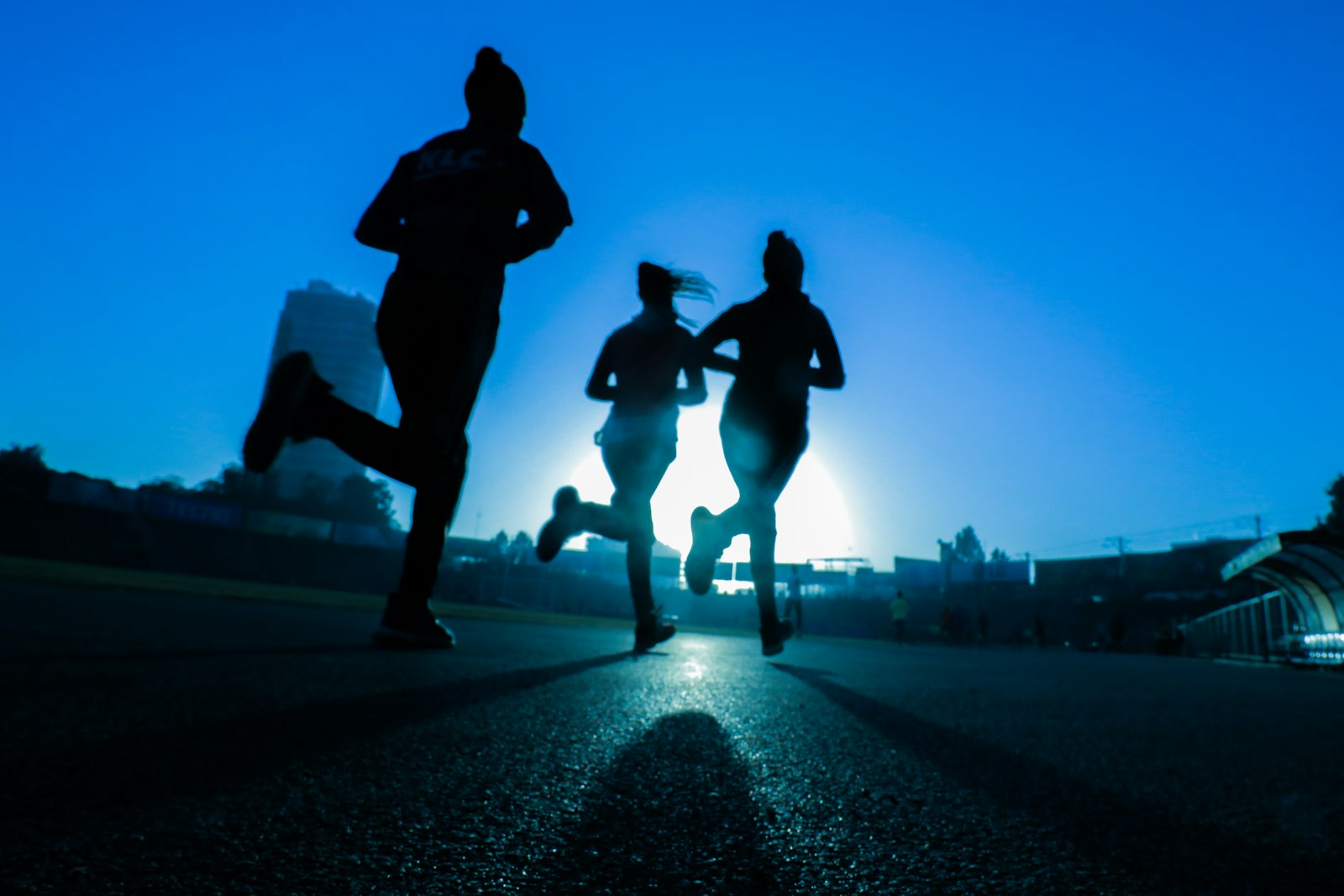 Run club silhouettes on a dawn city street