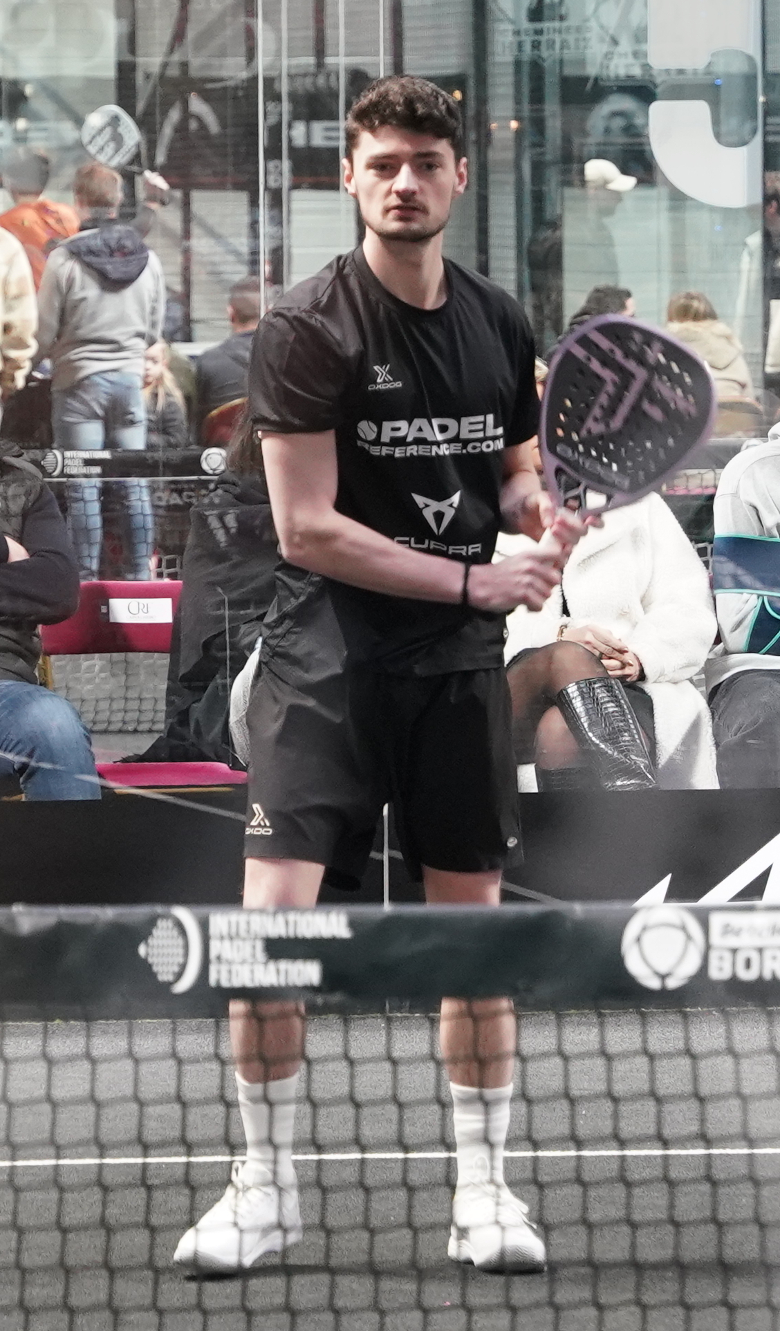Coach with racket bag in branded shirt